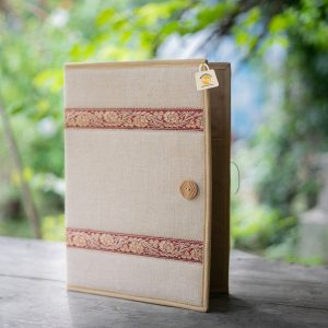 FF 012 standing partly open, with a light neutral cover, two maroon-and-gold floral bands, tan edging and a round brown button.