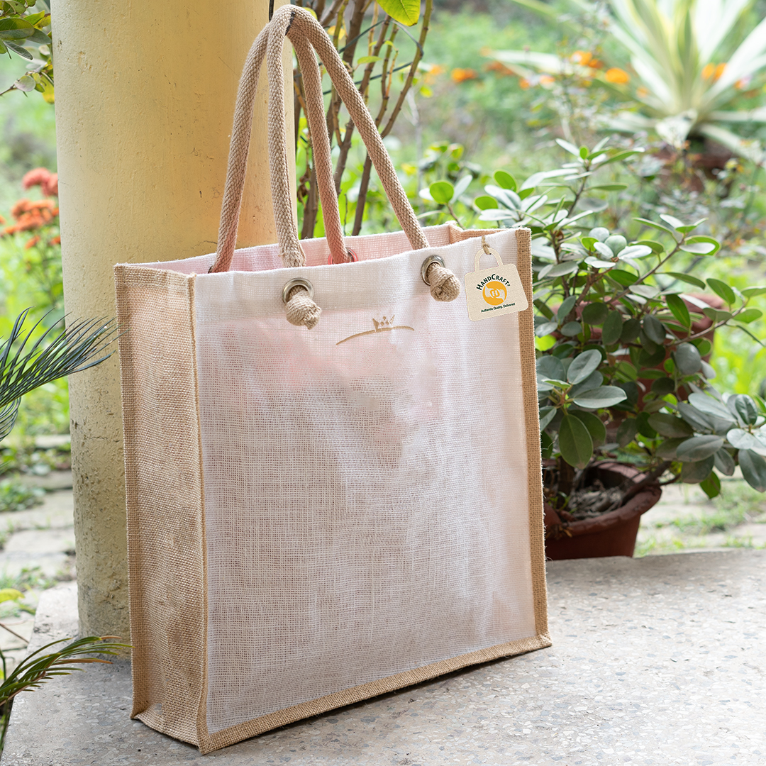 Plain jute tote bag with a pale front panel, natural jute side gussets and rope handles fitted through eyelets
