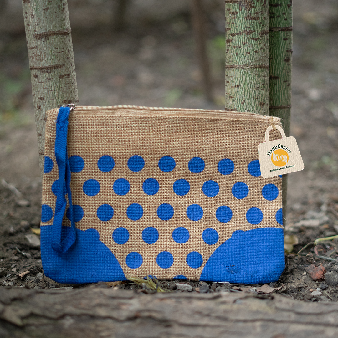 Natural-colour pouch with blue polka dots, a zip and a wrist loop.